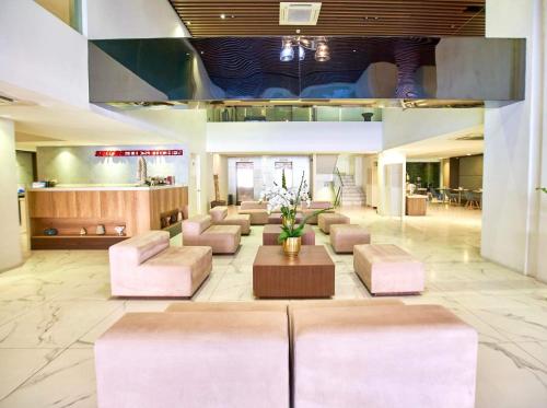 a lobby with couches and a table in a building at Ramada Encore by Wyndham Makati in Manila
