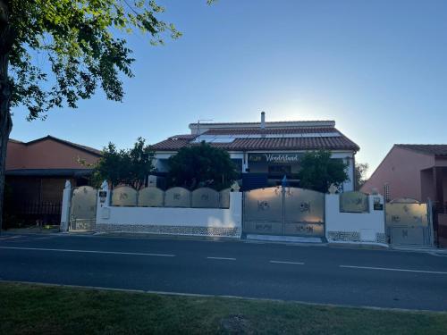 a house with a white fence on the side of a street at Wonderland in San Teodoro