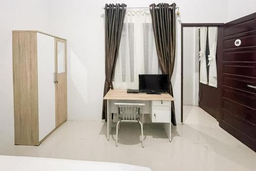 a room with a desk with a computer on it at An Nisa Homestay Syariah Aceh Mitra RedDoorz in Cotgirek
