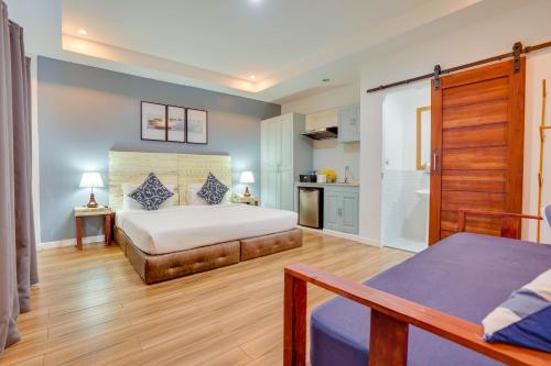 a bedroom with a large bed and a kitchen at The Mansion Boutique Hotel in Mabalacat