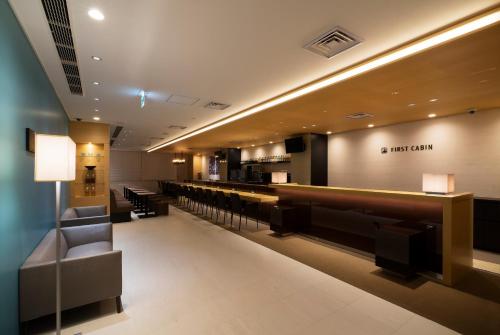 a lobby of a hotel with chairs and a bar at First Cabin Shinbashi Atagoyama in Tokyo