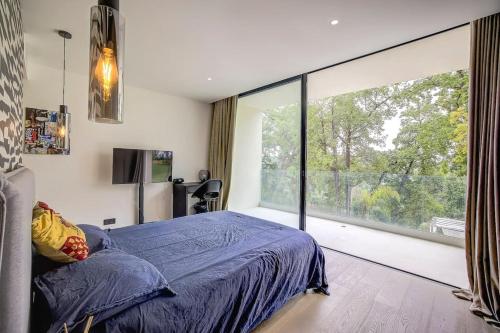 une chambre avec un lit et une grande fenêtre dans l'établissement Luxueuse Villa californienne à Opio, à Opio