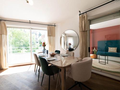 une salle à manger avec une table, des chaises et un miroir dans l'établissement L'élégant - Terrasse et climatisation, à Montpellier