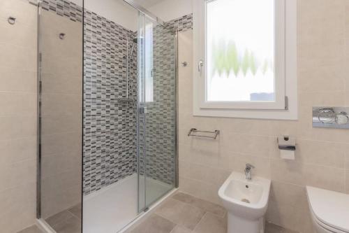 a bathroom with a shower and a toilet and a sink at Villino in centro con cortile interno, wifi e aria condizionata in Codigoro