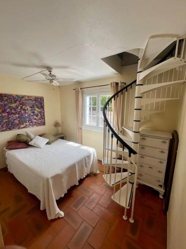 une chambre avec un lit et un escalier en colimaçon dans l'établissement Villa paisible vue panoramique, au Lavandou