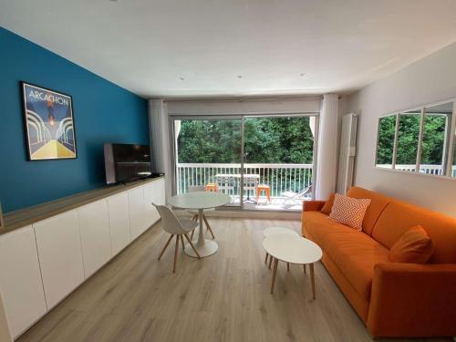 un salon avec un canapé orange et une table dans l'établissement ARGUIN studio cabine rénové coeur de ville, à Arcachon