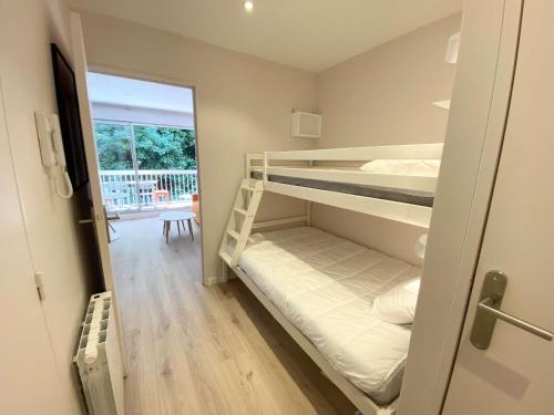 Cette chambre comprend 2 lits superposés et un couloir. dans l'établissement ARGUIN studio cabine rénové coeur de ville, à Arcachon