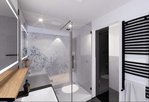 een badkamer met een glazen douche en een wastafel bij Alm- & Wellnesshotel Alpenhof in Schönau am Königssee