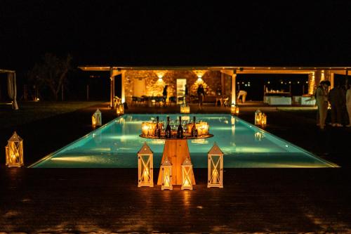 a swimming pool at night with candles and lights at Podere Pietravento in Campiglia Marittima