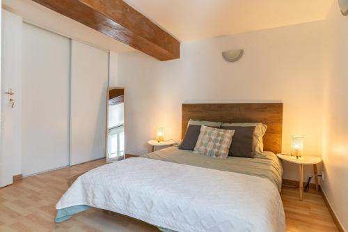 une chambre avec un grand lit et deux lampes dans l'établissement Le Midi - duplex climatisé - proche plage, à La Ciotat