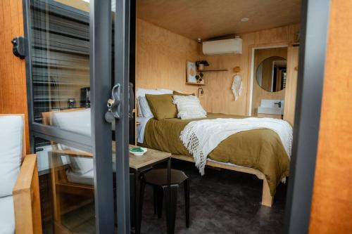 a small bedroom with a bed and a bathroom at Cass Bay Retreat with Outdoor Bath Christchurch in  Lyttelton