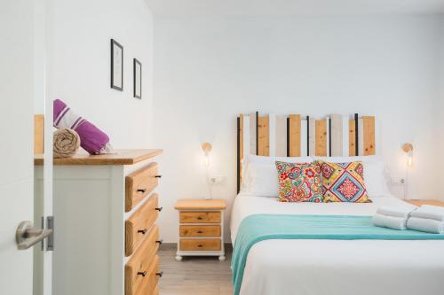 Apartamento Jávea Puerto في خافيا: غرفة نوم مع سرير مع اللوح الأمامي الخشبي