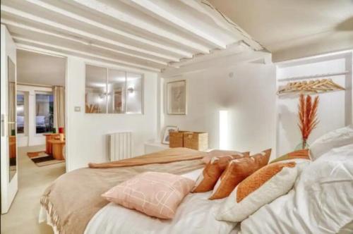 une chambre avec un grand lit avec des oreillers dessus dans l'établissement Geranimus Lombards : heart of Paris, à Paris