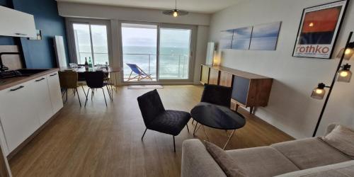 un salon avec un canapé et une table dans l'établissement Grand Pavois - Appartement de standing - Vue mer -, à Les Sables-dʼOlonne