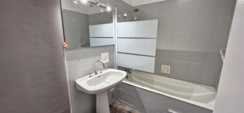 une salle de bain avec un lavabo, des toilettes et une douche dans l'établissement Grand Pavois - Appartement de standing - Vue mer -, à Les Sables-dʼOlonne