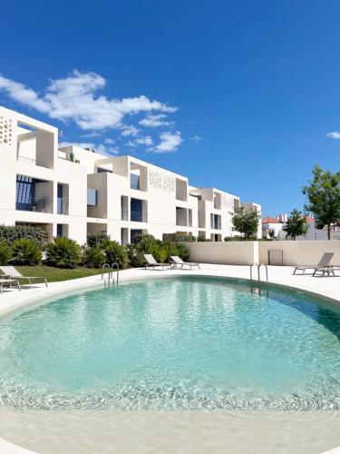 a large swimming pool in front of a building at Forte House T2 by Portugal Hideaway in Tavira