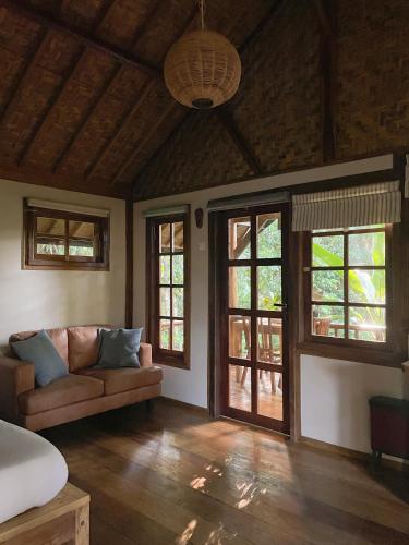 a living room with a couch and some windows at Santai House in Tetebatu