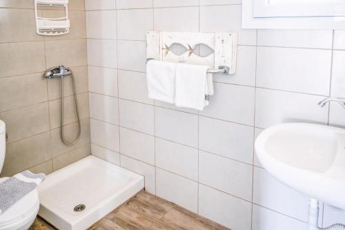 a white bathroom with a toilet and a sink at Brunis Apartments in Nei Poroi