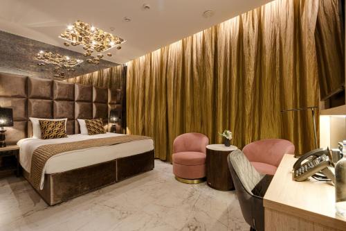 una camera d'albergo con un letto e due sedie di Art Suites Luxury Hotel a Cracovia