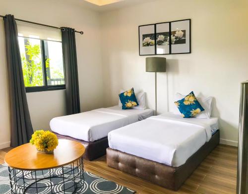 a hotel room with two beds and a table at The Mansion Boutique Hotel in Mabalacat