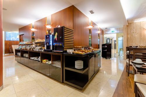 リスボンにあるトゥリン ヨーロッパ ホテルの食べ物が展示されているレストランのビュッフェライン