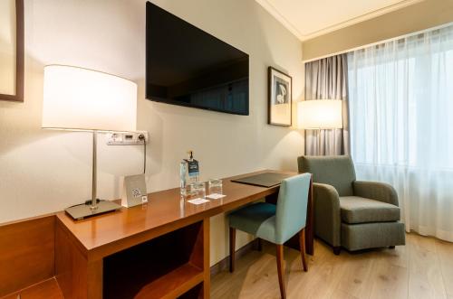 a hotel room with a desk and a chair at TURIM Europa Hotel in Lisbon