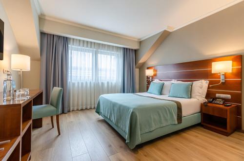ein Hotelzimmer mit einem Bett und einem Schreibtisch in der Unterkunft TURIM Europa Hotel in Lissabon