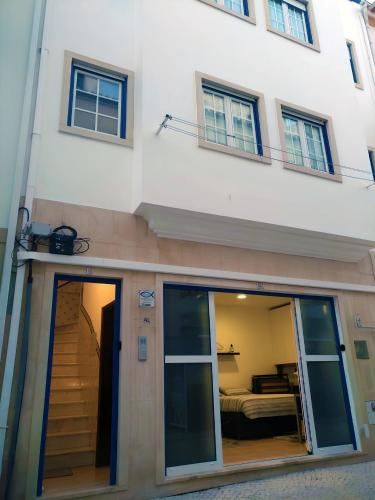 a large white building with a staircase and a bedroom at SUNAO LdA in Nazaré