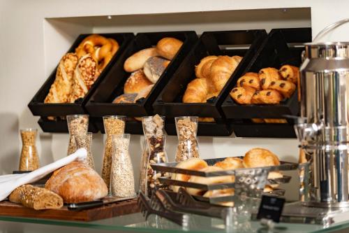 a bunch of different types of pastries on a shelf at Central Hotel in Villingen-Schwenningen