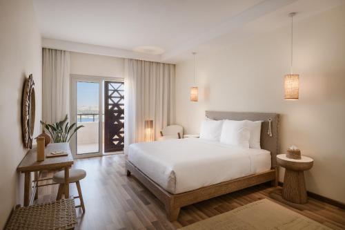 a bedroom with a large white bed and a window at The Zen Wellness Resort in Aswan