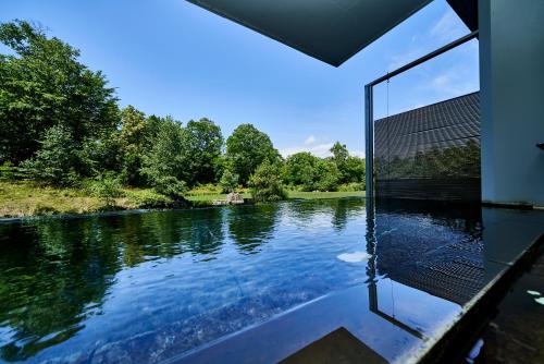 a swimming pool with a view of a river at Hakodate-Onuma Prince Hotel in Nanae