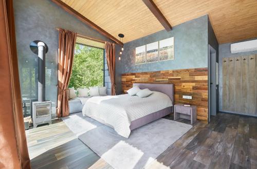 een slaapkamer met een bed en een groot raam bij Ramiau - su gamta 