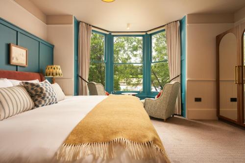 a bedroom with a large bed with blue windows at Mill on the Exe in Exeter