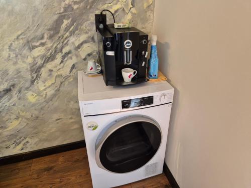 a washing machine with a blender on top of it at Casa Denis la 50m de Castel! in Hunedoara