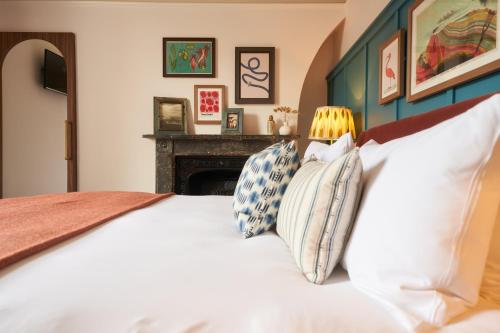 a bedroom with a bed with pillows and a fireplace at Mill on the Exe in Exeter