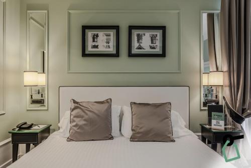 a bedroom with a white bed with two night stands at HOTIDAY Room Collection - Napoli Diaz in Naples