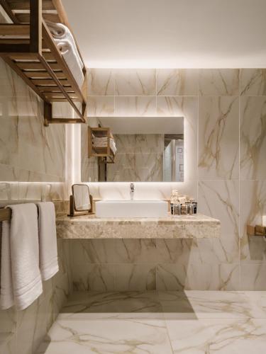 a white bathroom with a sink and a mirror at The Zen Wellness Resort in Aswan