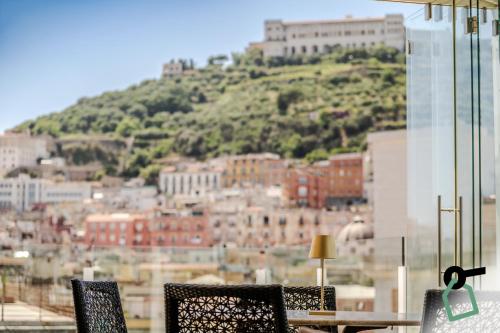 a table and chairs with a view of a city at HOTIDAY Room Collection - Napoli Diaz in Naples