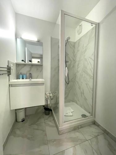 une salle de bain avec douche et lavabo dans l'établissement Le Rivage, joli appartement à 200 m des plages, à Menton