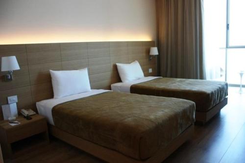 a hotel room with two beds and a window at Boutique Hotel in Beirut
