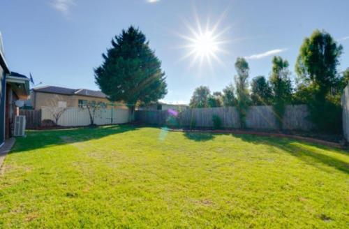 a backyard with a fence and a grass yard at YF Home Sweet Home FREE WIFI 4 bedroom beautiful house in Craigieburn