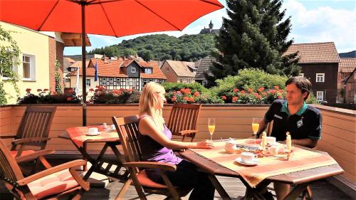 un uomo e una donna seduti a un tavolo su un patio di Ferienhaus Burgfried a Wernigerode