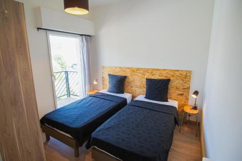 deux lits dans une petite pièce avec une fenêtre dans l'établissement -TERRAZZA- Concarneau hypercentre 3 balcons garage, à Concarneau