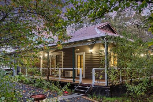 a small house with a front porch with lights at Serenity House Pemberton Cottage & Wellness Spa in Pemberton
