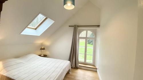 une chambre avec un lit blanc et une fenêtre dans l'établissement Le Cèdre, à Cambron