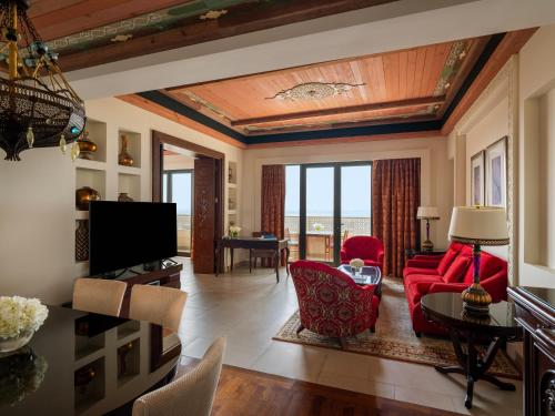 a living room with a red couch and a table at Sofitel Bahrain Zallaq Thalassa Sea & Spa in Manama