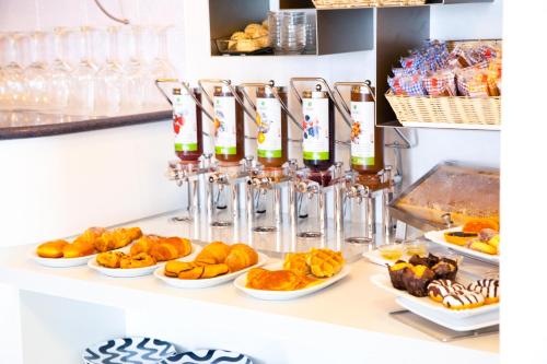 a counter with plates of food and wine bottles at Hotel Villa Anthea in Garda