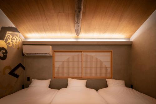 a bed in a room with a light above it at CONTEXTED-Sora SORA - Vacation STAY 78119v in Osaka