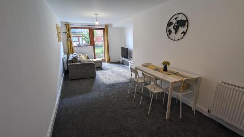 a living room with a table and chairs at 2-Bed Riverside Stay - Sleeps 6 & Pets Ok in Greenhithe