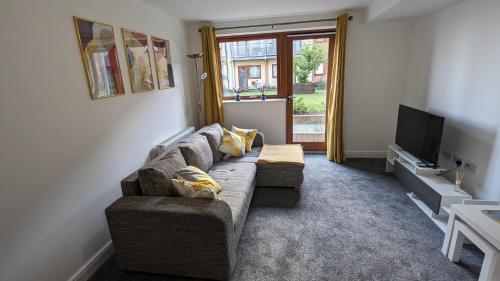 a living room with a couch and a television at 2-Bed Riverside Stay - Sleeps 6 & Pets Ok in Greenhithe